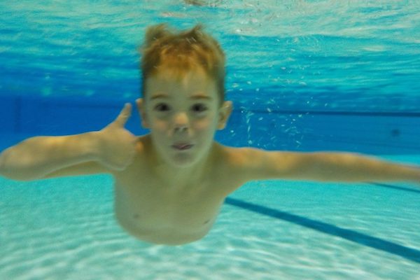 Jongen steekt duim op onderwater