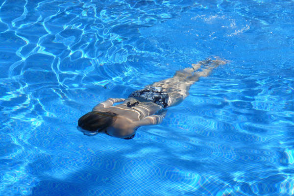 Vrouw zwemt onderwater in het binnenzwembad
