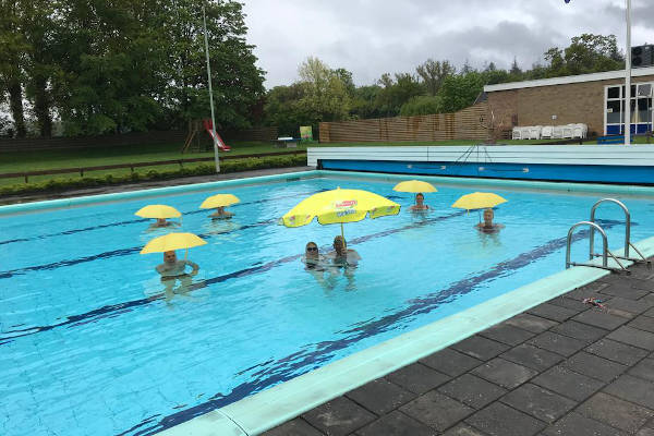 Zwembad Veenhuizen: Mensen onder paraplu