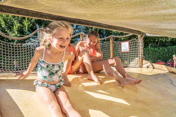 Meiden gaan van de glijbaan in het waterpark