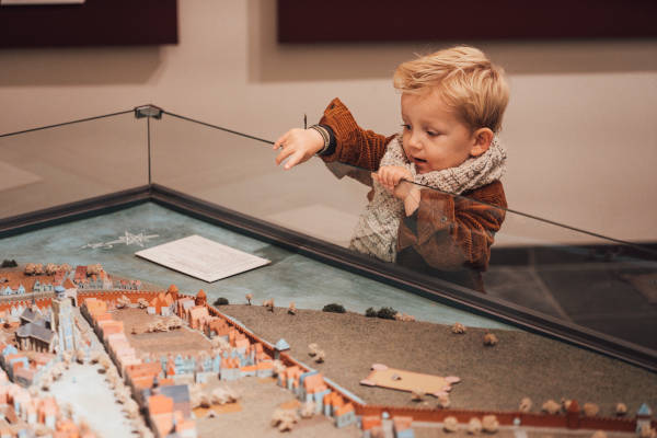 Jongen kijkt naar miniatuur gebouwen