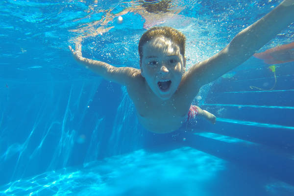 Kind zwemt in het openluchtzwembad
