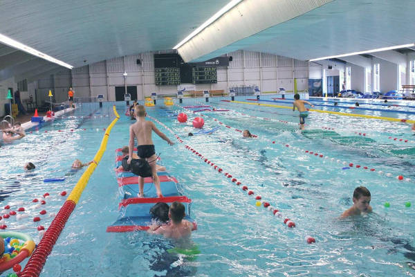 Kinderen spelen op de matten in het 50 meter bad