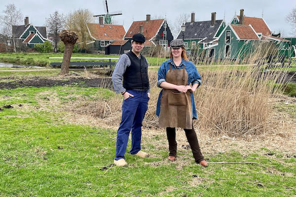 Dame en heer poseren samen op het platteland voor de molens