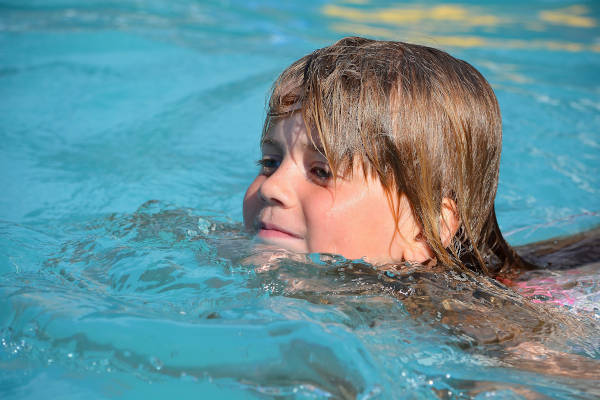 Kind zwemt in het buitenbad
