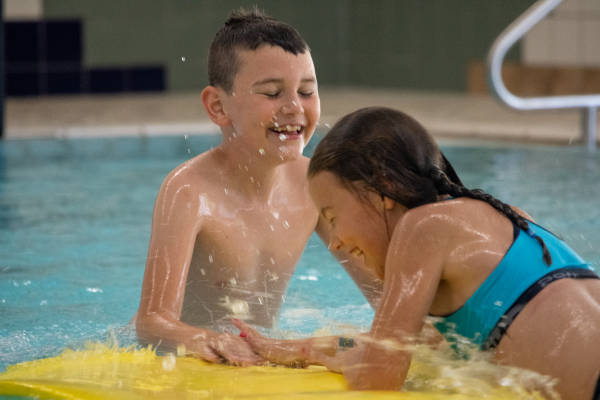 Kinderen hebben plezier op de mat in het zwembad