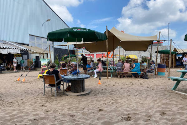 Relaxen op de banken in het zand onder de tent