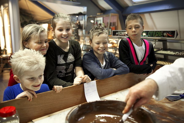 Kinderen kijken mee hoe de bon bons worden gemaakt