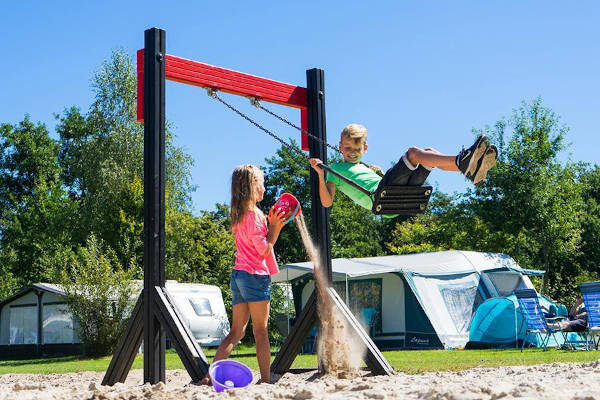 Spelen bij de schommel in de speeltuin