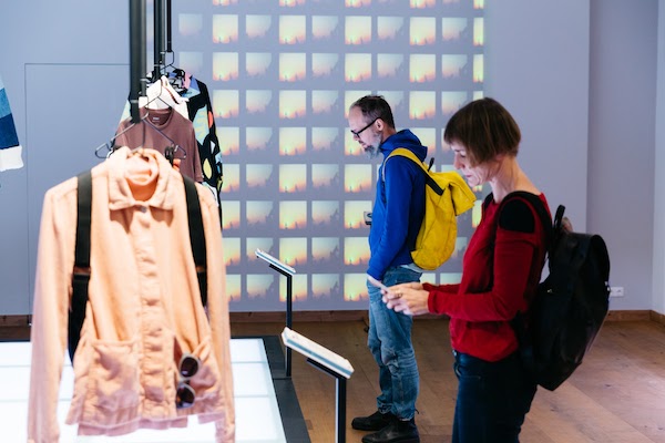 Mensen zijn aan het kijken naar de kleding in het museum