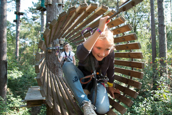 Klimbos Veluwe: Meisje kruipt door ton