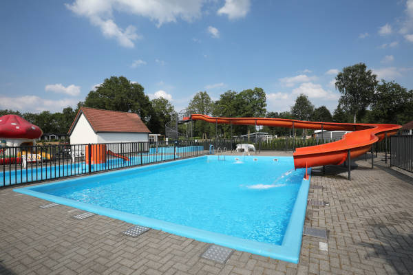 Het zwembad met de rode glijbaan