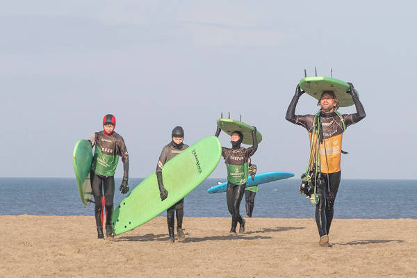 Mensen met surfplank op strand