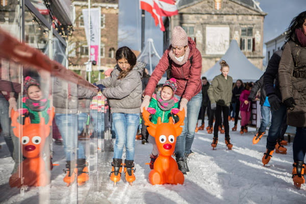 Kind aan het schaatsen met rendier steun op de ijsbaan