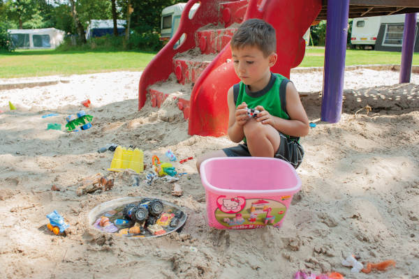 Jongen speelt in het zand