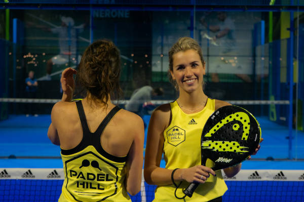 Vrouwen met een geel Padelhill hempje aan en racket in hun hand