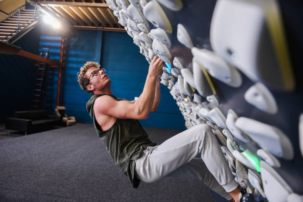 Boulderhal Krachtstof: Jongen klimt tegen de schuine wand op