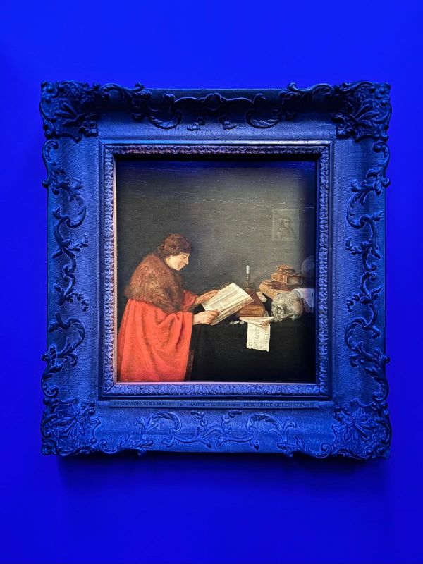 Een schilderij van een vrouw die een boek aan het lezen is