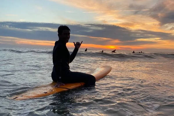Surfen met zonsondergang
