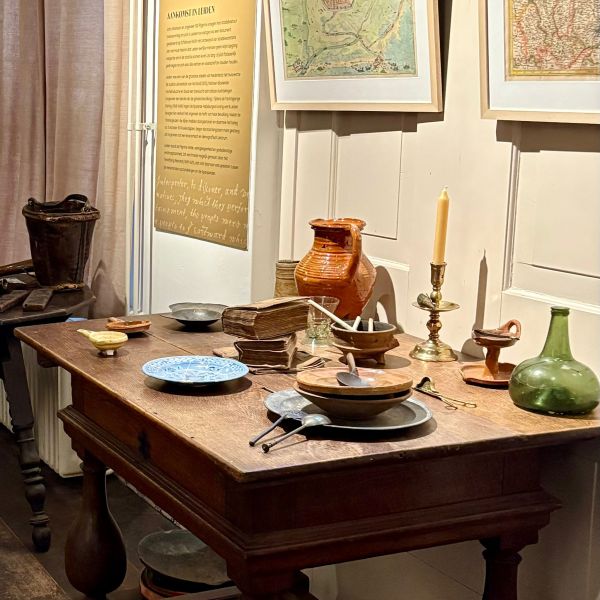 Pilgrim Museum: Tafel met borden, boeken, kaars, bestek etc.