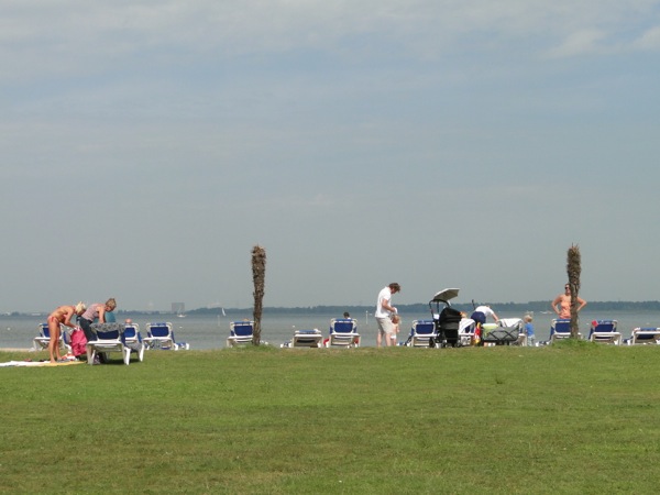 Kinderen spelen en ouders liggen aan het strandje