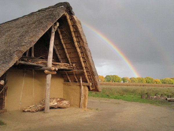 Regenboog achter prehistorisch gebouw