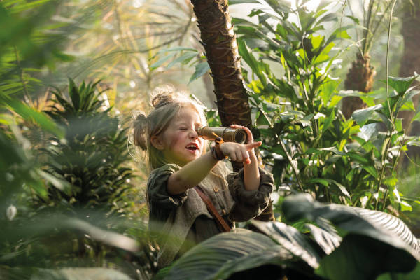 Meisje met verrekijker in de jungle